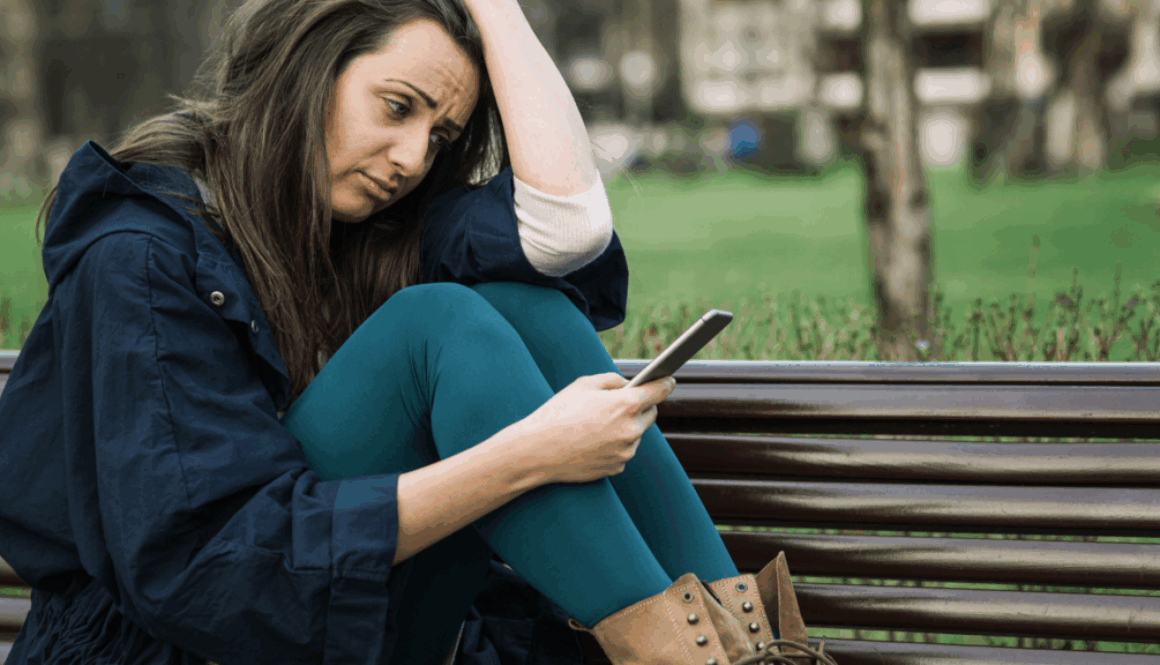 Giovane solo con smartphone, simbolo della solitudine sociale