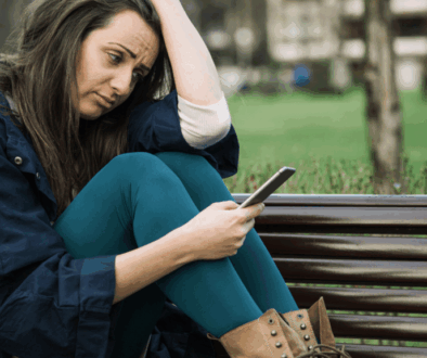 Giovane solo con smartphone, simbolo della solitudine sociale